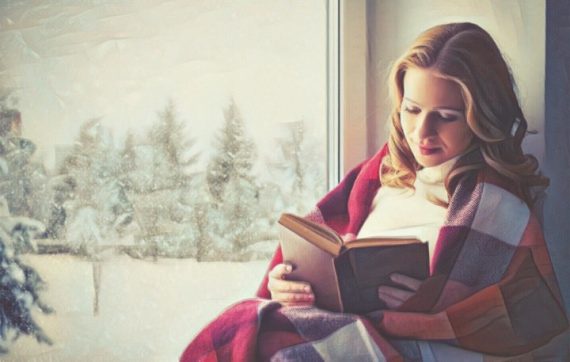 Mujer leyendo un libro cerca de la ventana
